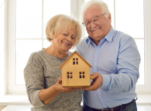 happy older couple with house