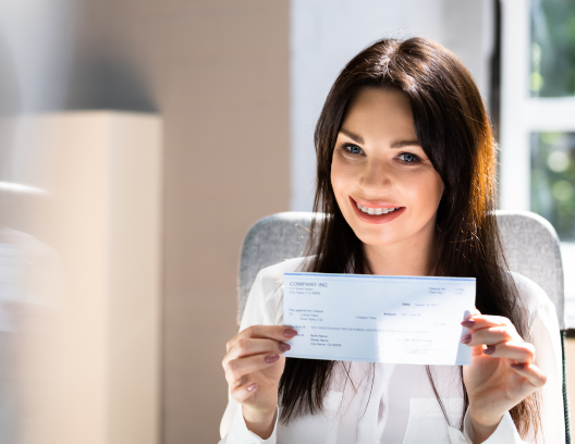 young woman holding paycheck and smiling
